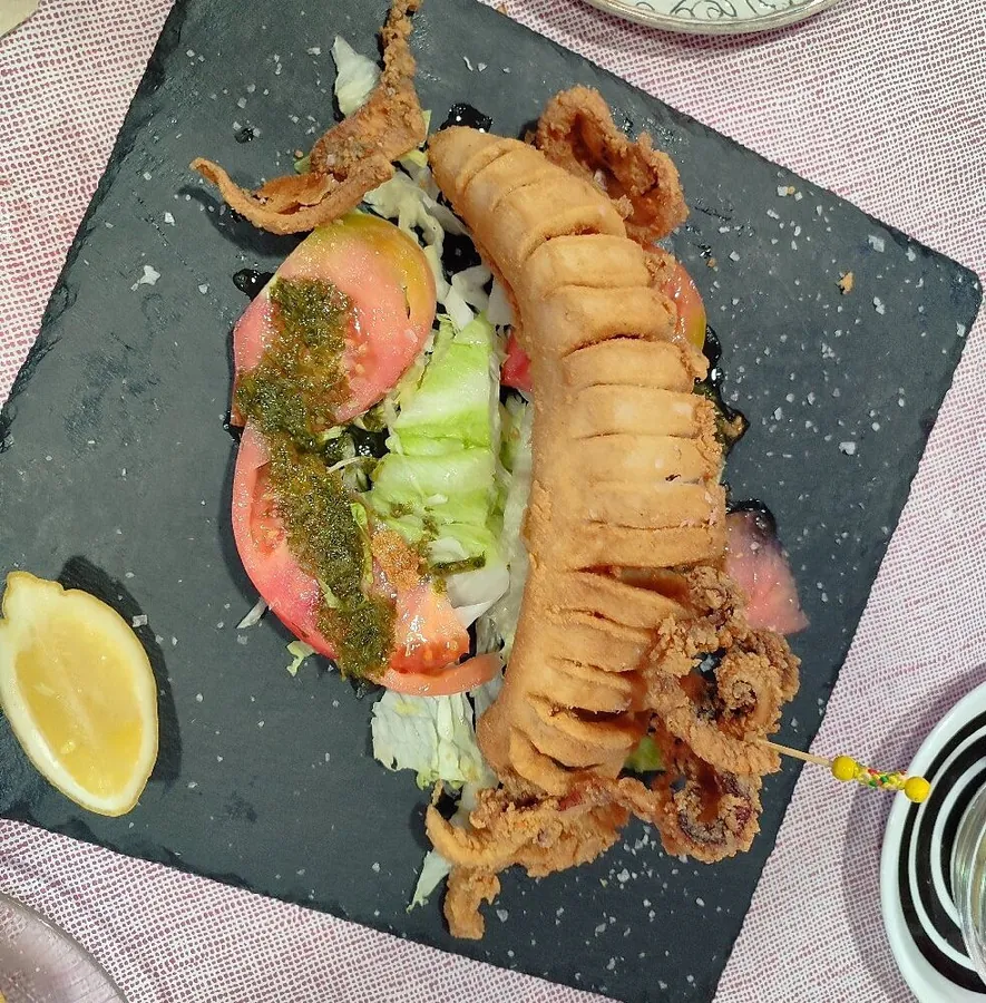 Calamar entero frito con ensalada, tomate y limón